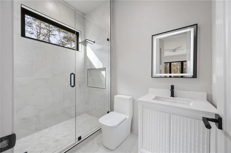 Bathroom featuring vanity, a stall shower, and marble finish floors