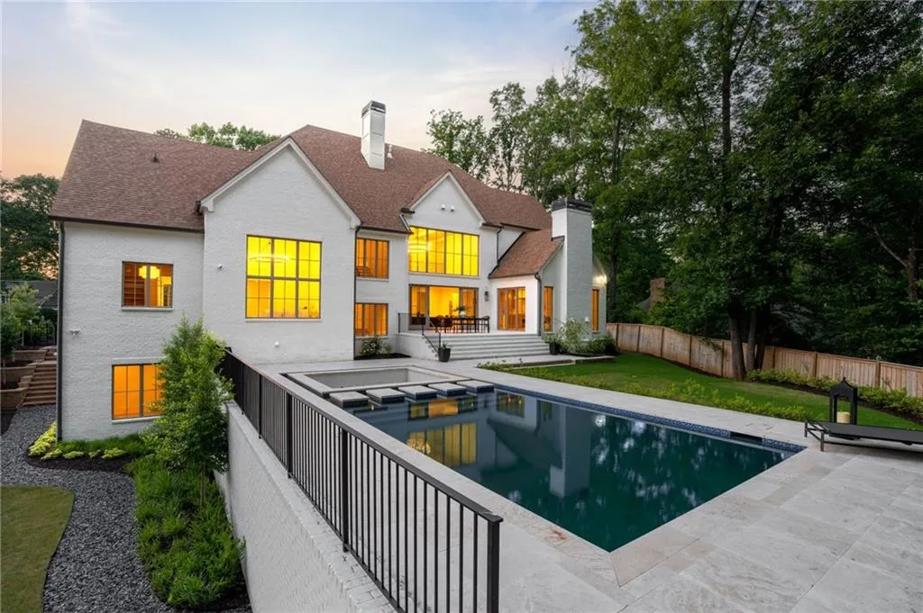 Back of house featuring a chimney, roof with shingles, and a patio area