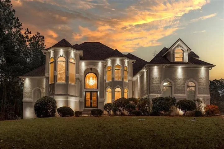 View of front of property featuring french doors, a front lawn, and stucco siding