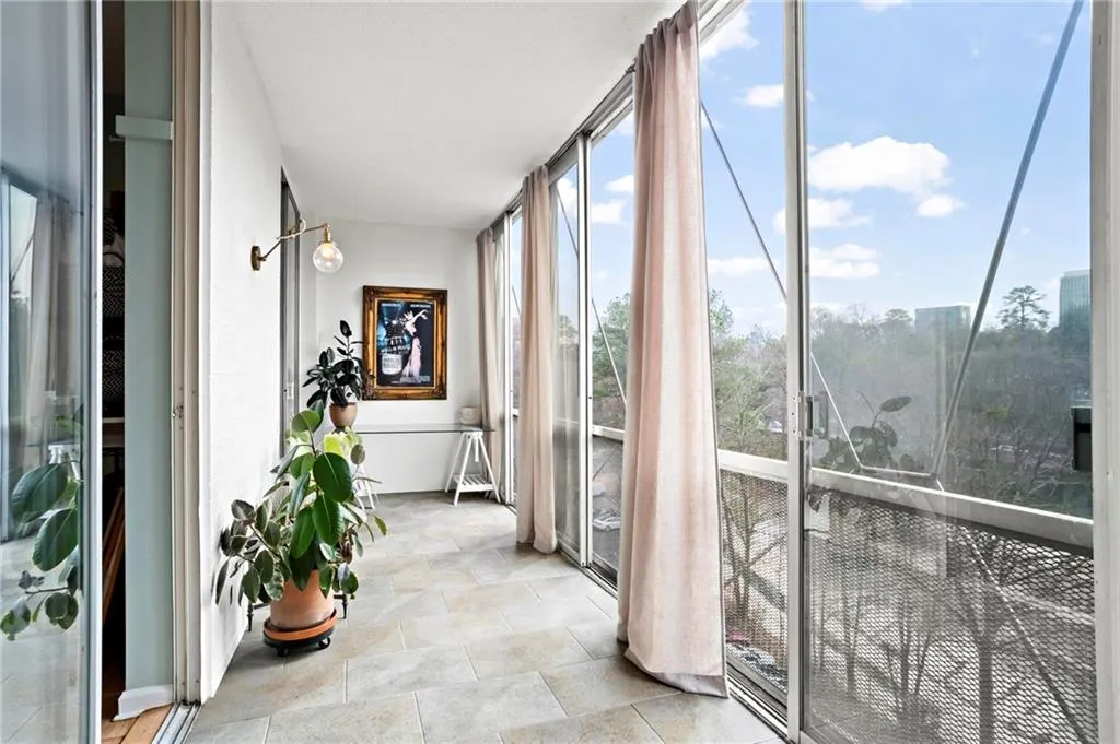Sunroom / solarium with stone finish floors and floor to ceiling windows