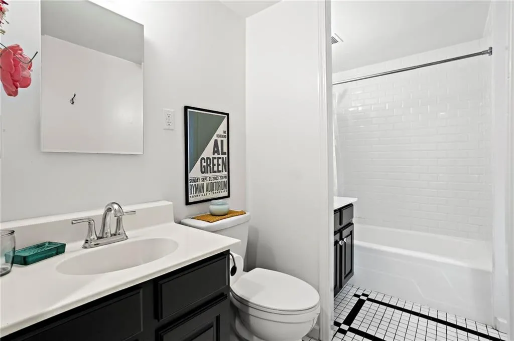 Bathroom with vanity, tile patterned flooring, and shower / washtub combination