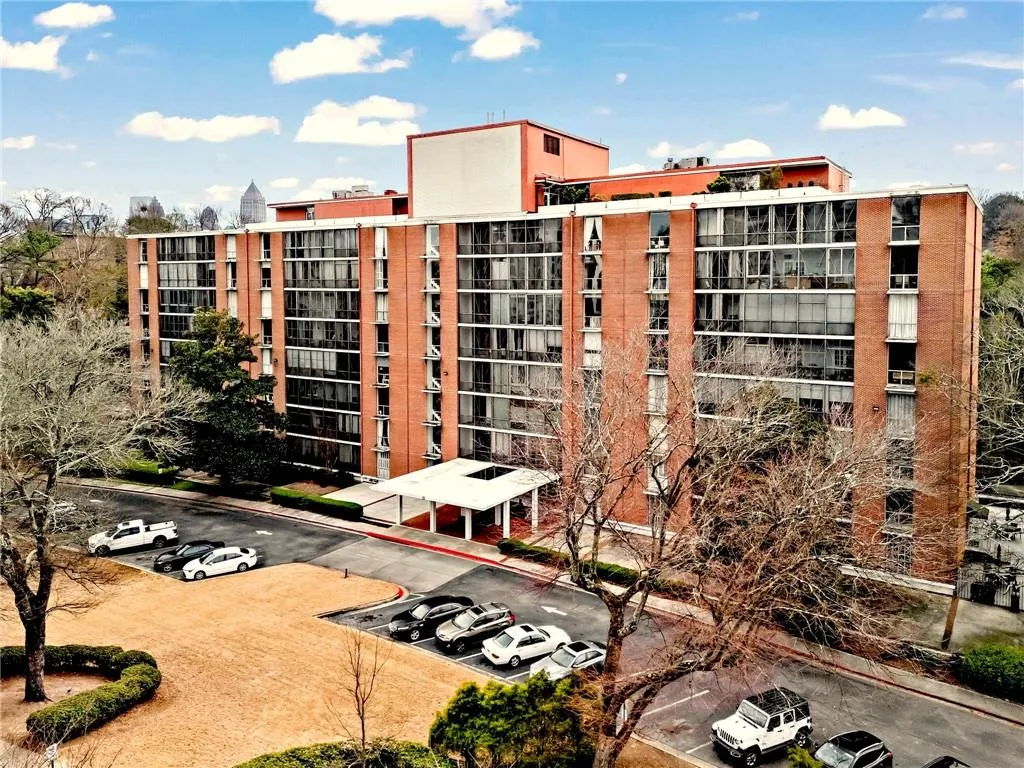 View of apartment building / complex with uncovered parking