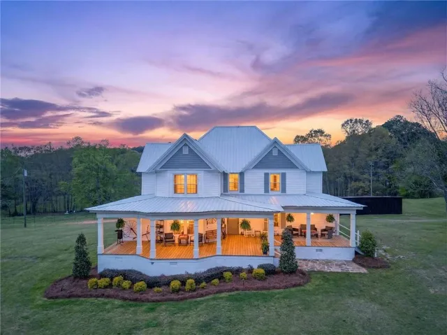 Front of property featuring a porch, a lawn, and a metal roof