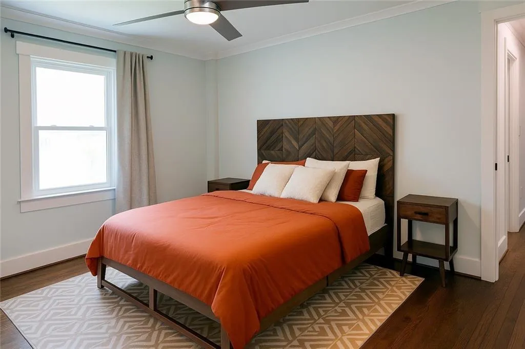 Bedroom with wood finished floors, crown molding, and a ceiling fan