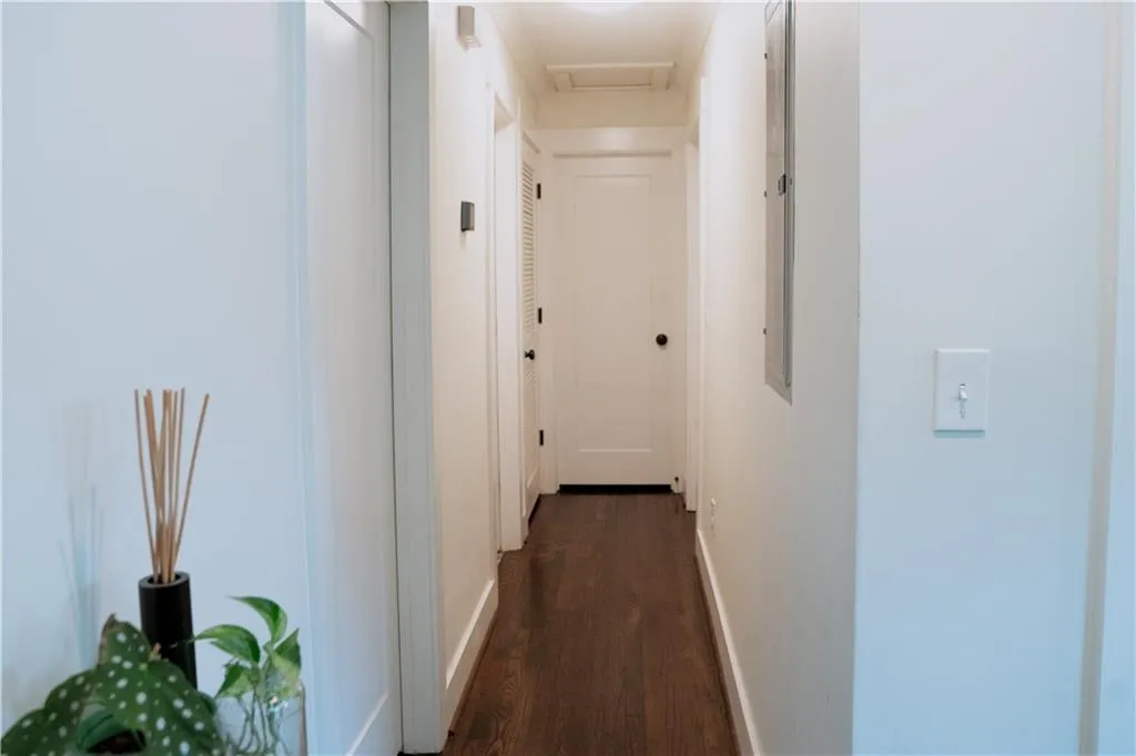 Hallway featuring dark wood-type flooring and attic access