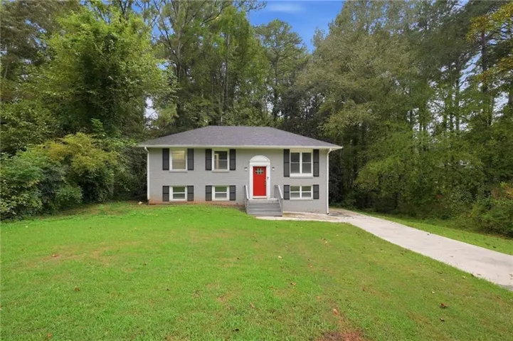 Gray exterior with black window shutters and a vibrant red front door