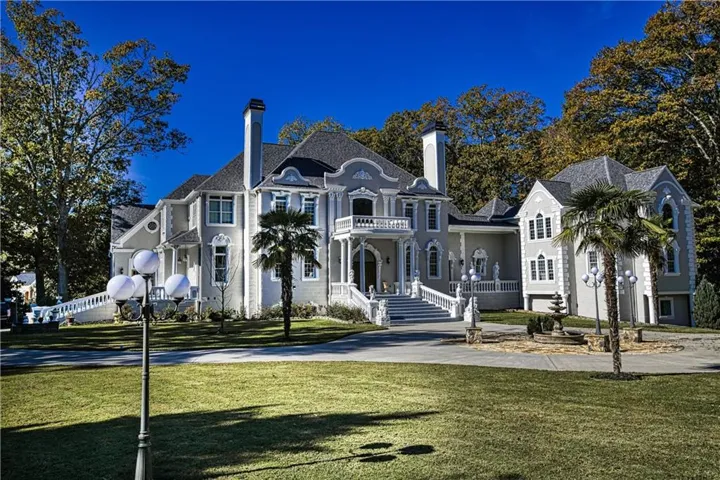 View of front facade with a chimney and a front lawn