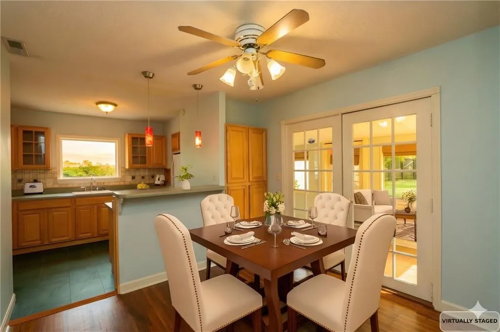 Dining area featuring dark wood-style flooring and ceiling fan