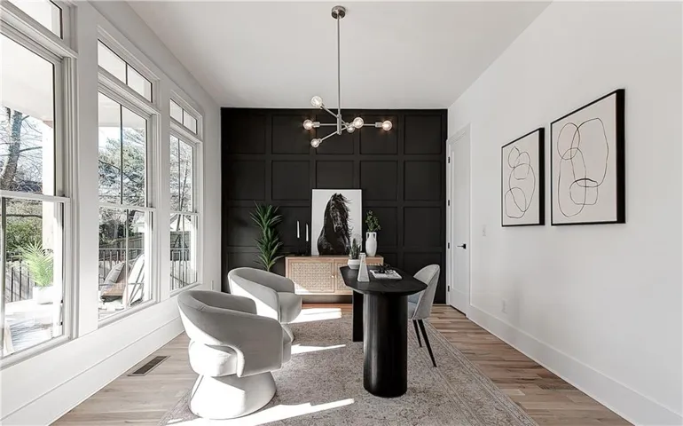 Expansive window wall, wood-finish flooring, accent panel wall, contemporary ceiling fixture, and a built-in storage cabinet