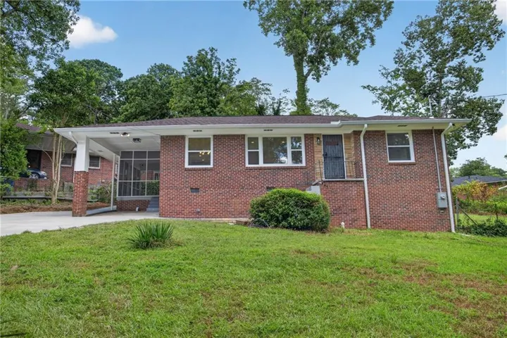 Brick exterior with white window frames, covered entry, and screened porch