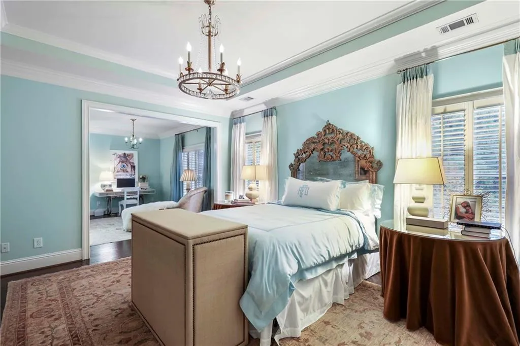 This calming primary bedroom has tray ceilings