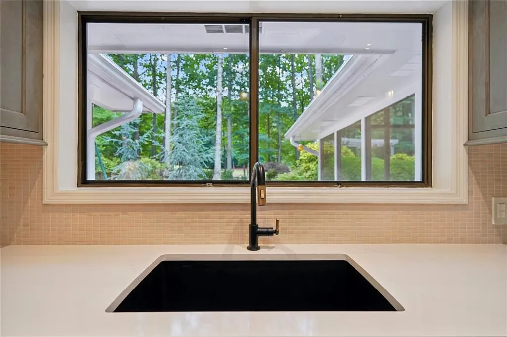 sliding glass window over the sink looking into the backyard and golf course