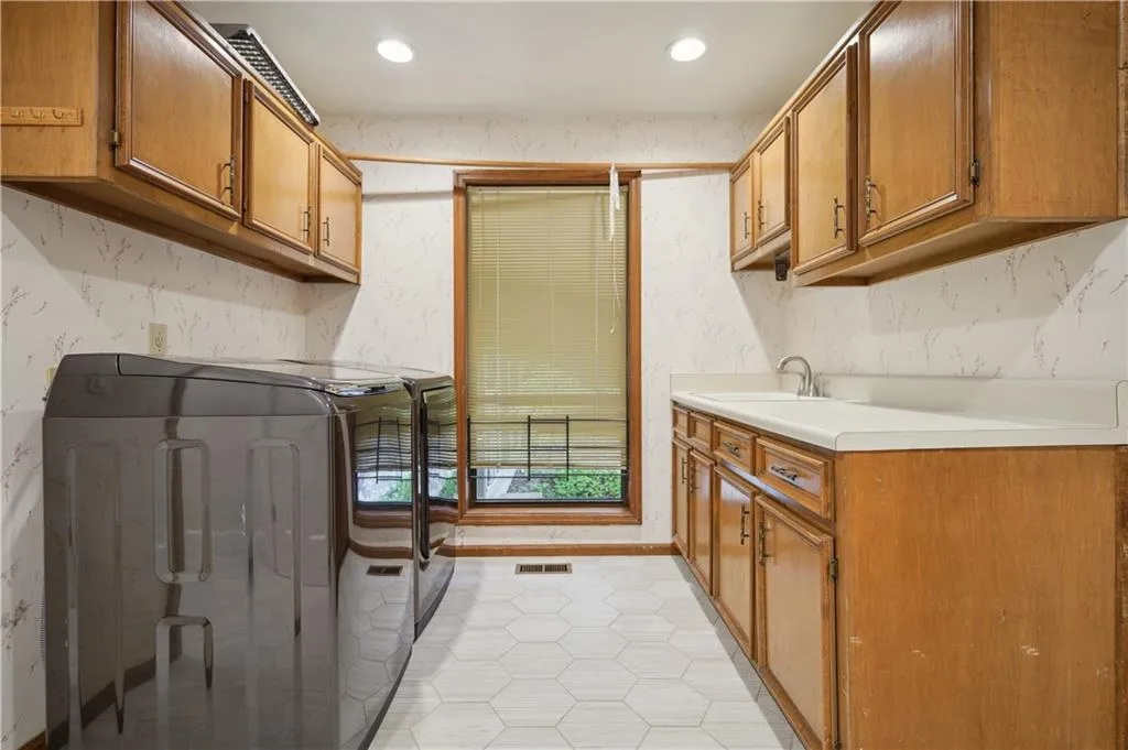 Laundry room with sink and cabinetry
