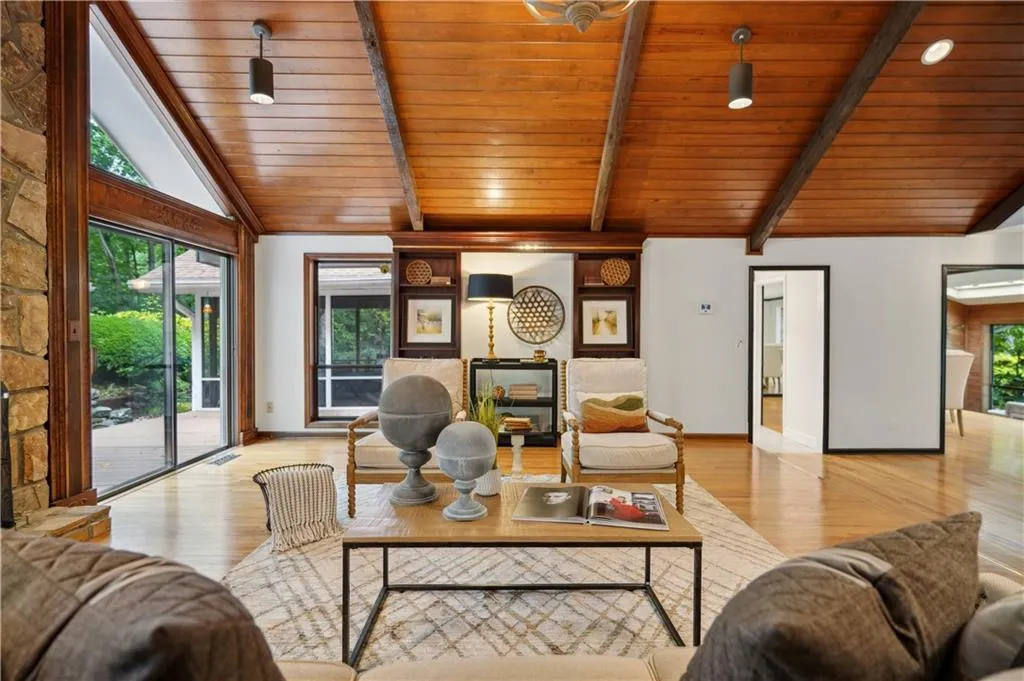 Living room with beamed ceiling, high vaulted ceiling, hardwood / wood-style floors, and wood ceiling