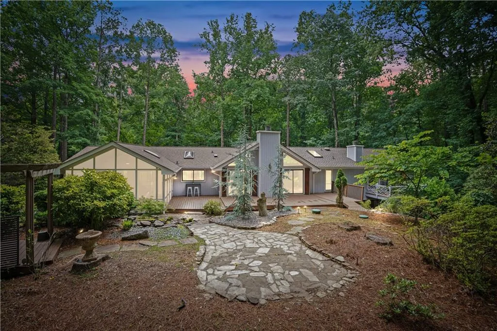 Back house at dusk featuring a deck