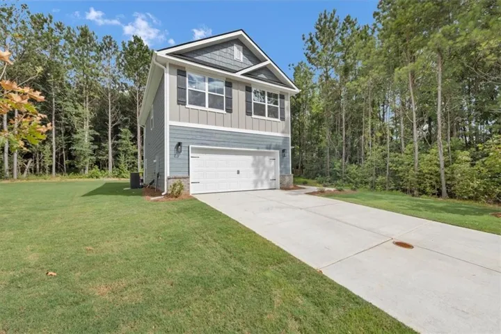 Contemporary two-story residence featuring a two-car garage, mixed siding exterior, and dark shutters