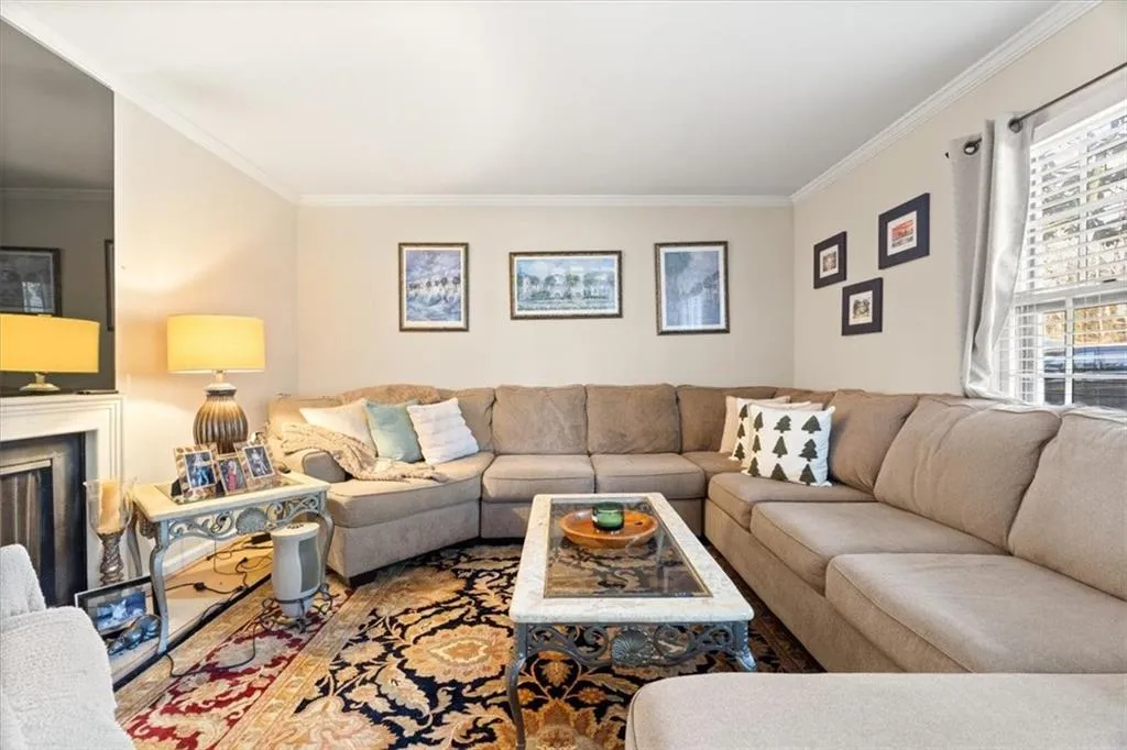 Living room featuring ornamental molding and a fireplace
