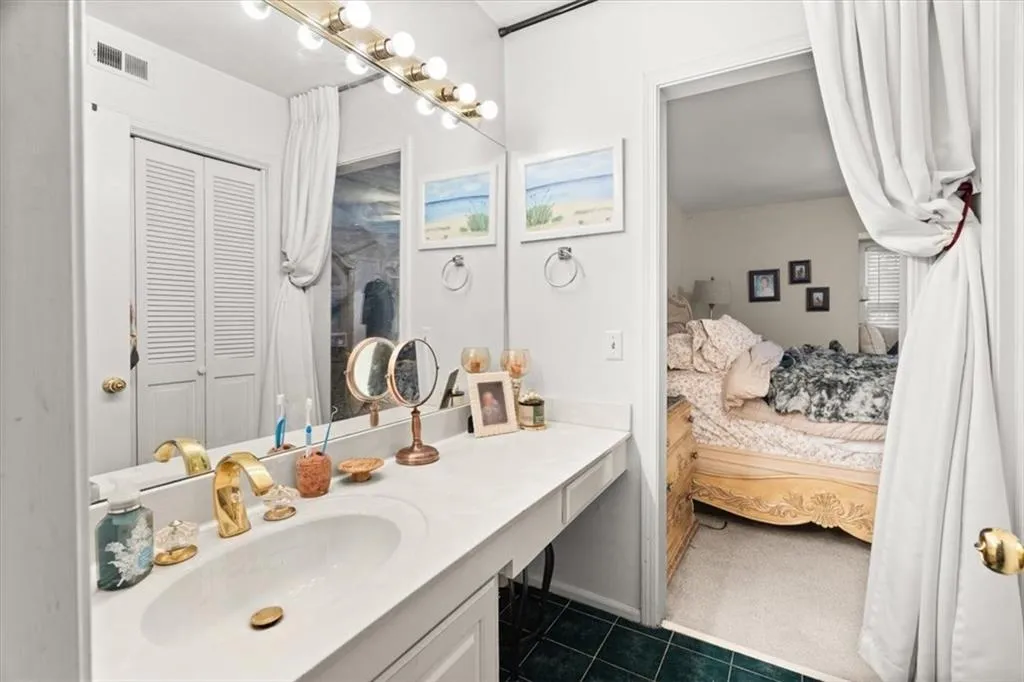 Ensuite bathroom with vanity and dark tile patterned flooring