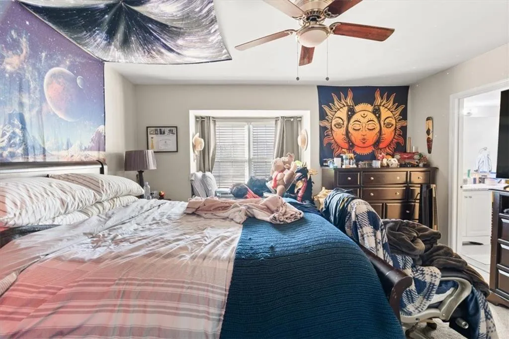 Bedroom featuring ceiling fan and connected bathroom