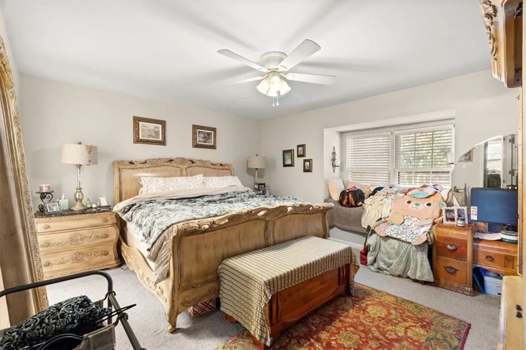 Carpeted bedroom featuring a ceiling fan
