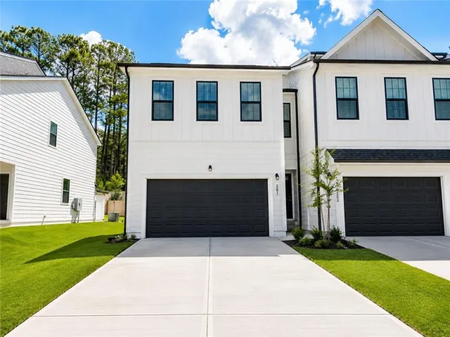 Modern townhome exterior featuring white siding and black trim accents
