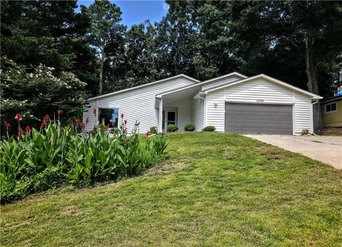 White siding exterior with an attached garage featuring a dark gray garage door