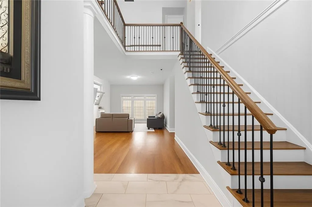 The powder room and laundry room are conveniently located to the right of the entryway, just beyond the stairwell. The custom staircase leads to the upper level of stairs.