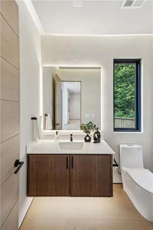 Half bathroom featuring vanity and toilet