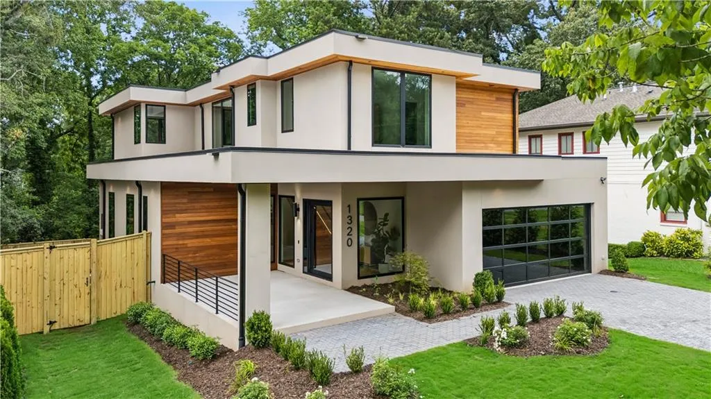Contemporary home with stucco siding, decorative driveway, and an attached garage