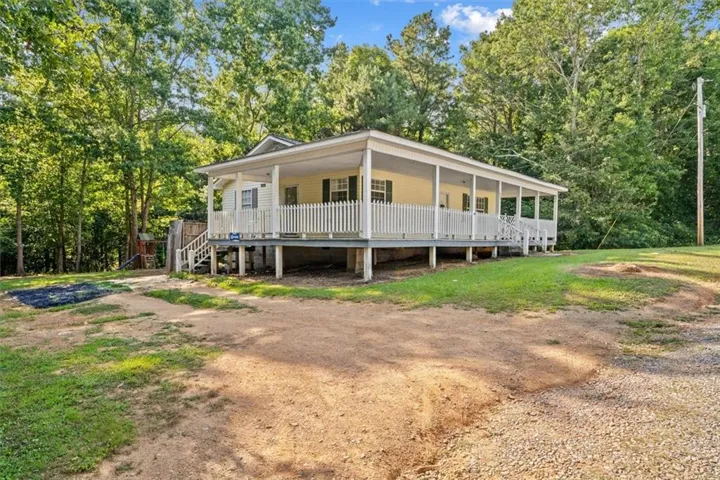 Single-story home featuring a full-length covered front porch with white picket railings and supporting columns
