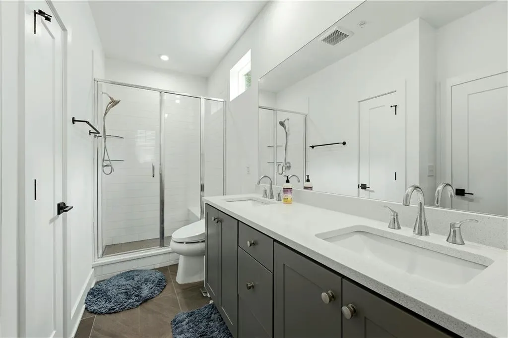 Dual vanity with light-toned countertop, sleek chrome fixtures, and integrated sinks