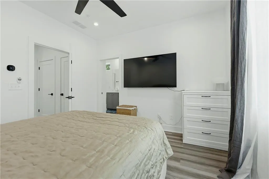 White walls and trim, wood-finish flooring, recessed lighting, and a ceiling fan