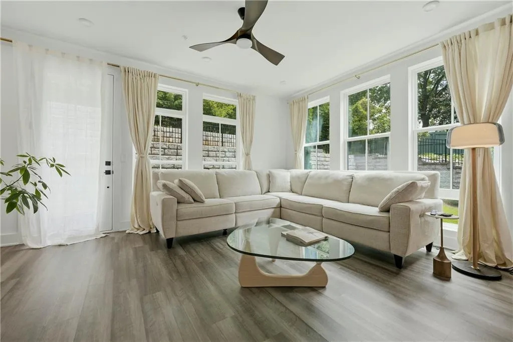 Living area featuring wood-finish flooring, recessed lighting, and a modern ceiling fan