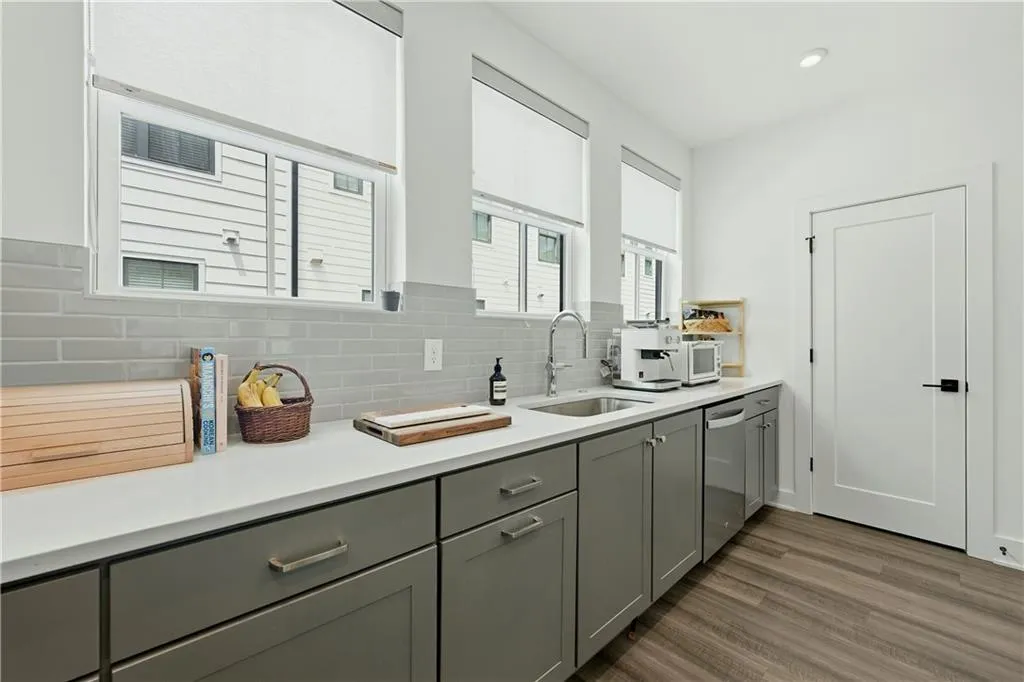 Kitchenette featuring gray shaker-style cabinetry, white countertops, subway tile backsplash, and wood-finish flooring