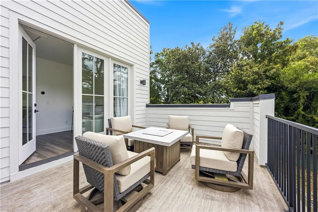 Outdoor patio featuring a black metal railing and white shiplap siding