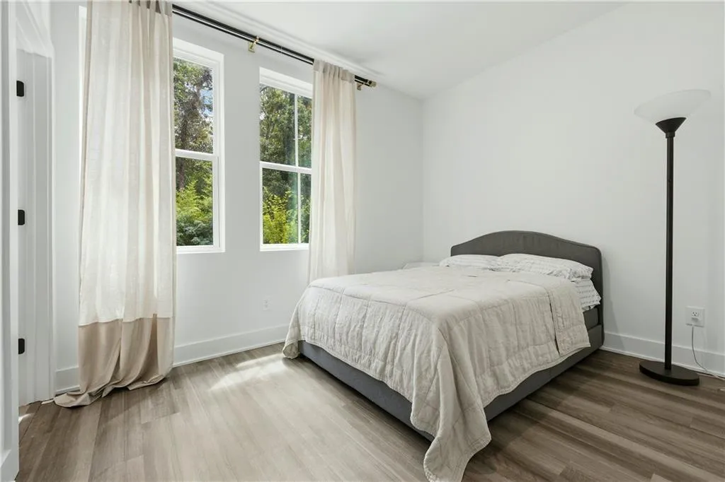 Wood-finish flooring, white walls, and two large windows with white trim