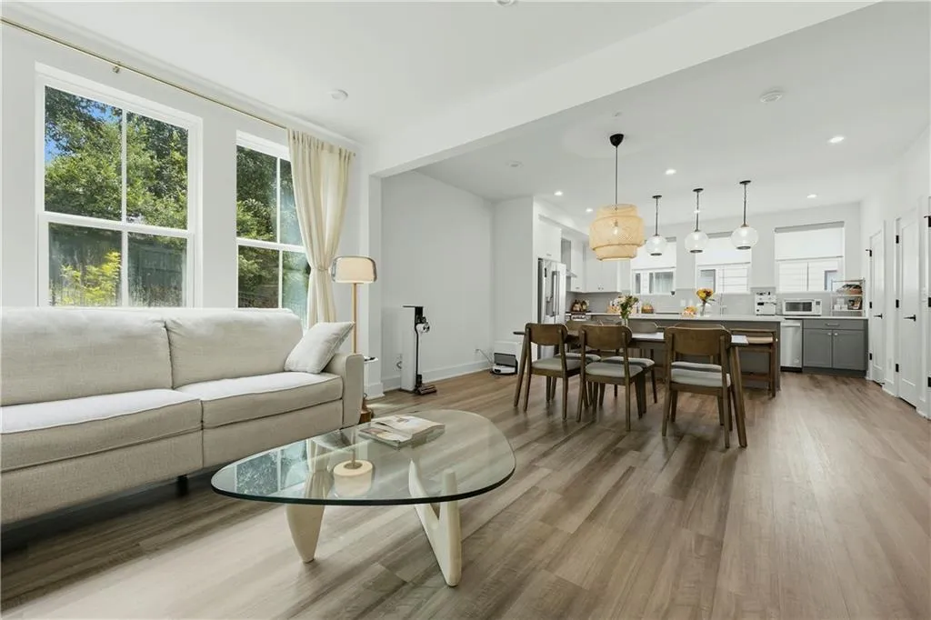 Open-concept living space featuring wood-finish flooring, recessed lighting, and large windows