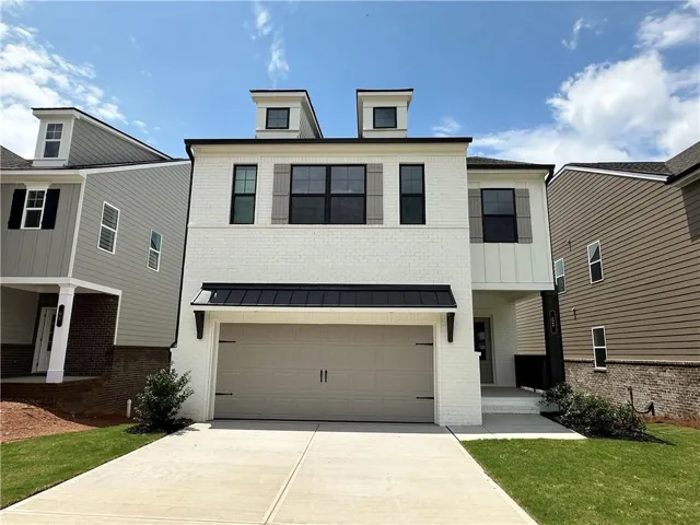 Contemporary facade featuring white brick, black-framed windows, and two dormer windows