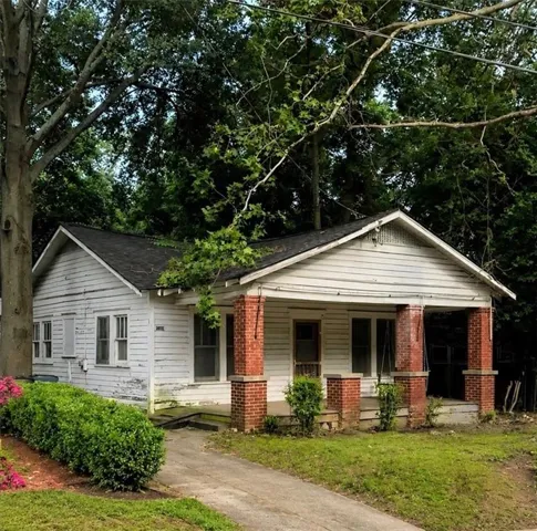 Single-story residence featuring a covered front porch with brick columns and a gabled roof