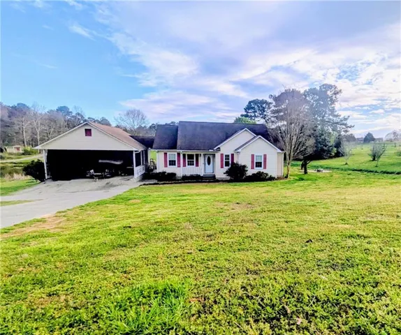 Ranch-style home featuring a front lawn and driveway