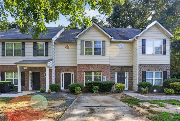 Brick and siding exterior with dark shutters, dual-pane windows, and a covered entry