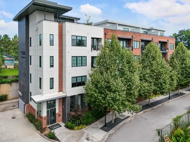 Contemporary multi-unit residential building featuring clean-lined modern architecture with mixed material façade including brick and fiber cement board accents