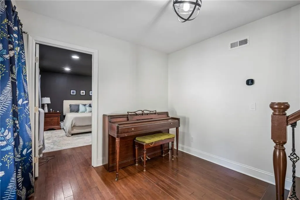 Hardwood-finish flooring, white trim, and a ceiling-mounted light fixture with an open cage design