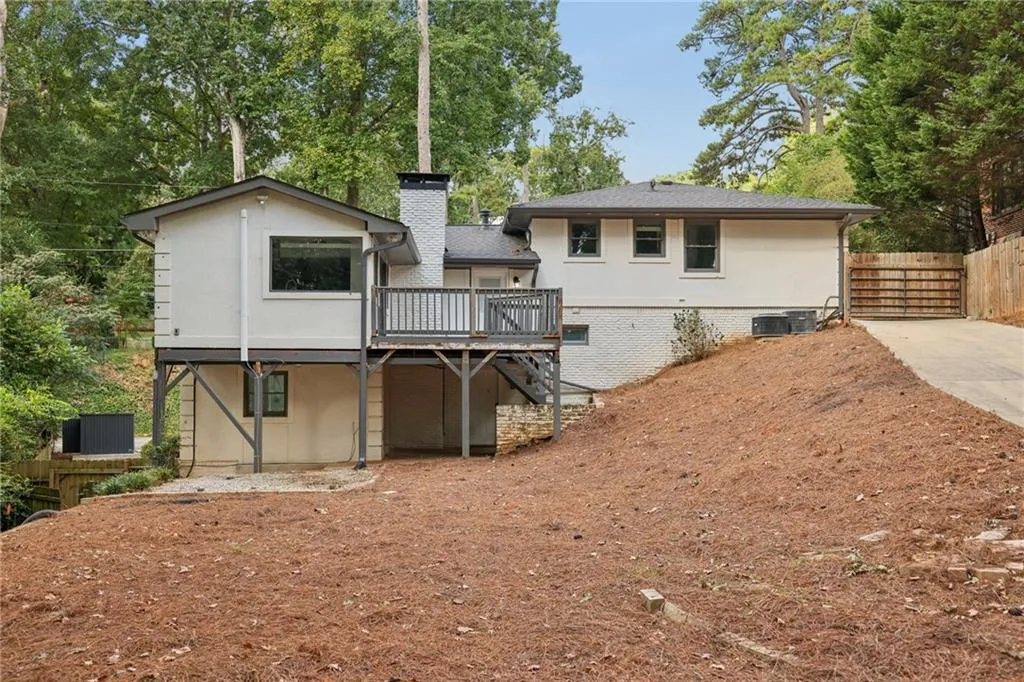 Multi-level exterior with a deck, a chimney, and a sloped landscape