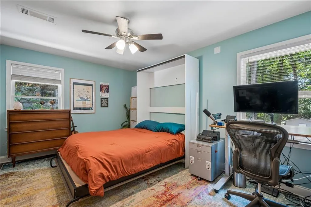 Recessed lighting, ceiling fan, two windows with blinds, light blue wall paint, and integrated wall shelving