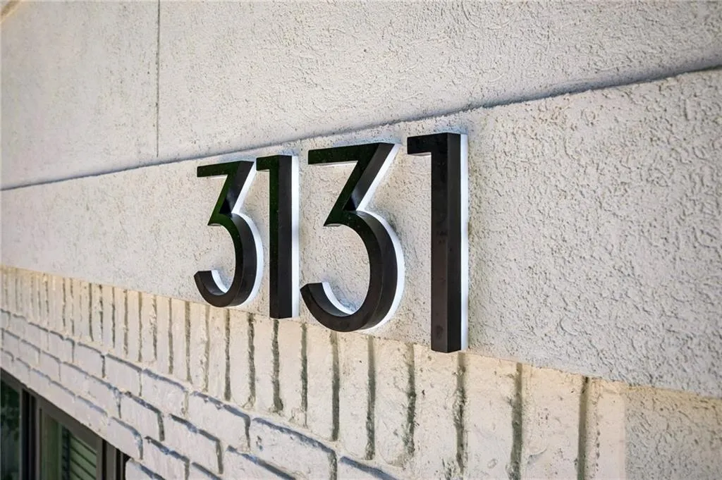 Modern numerical display, textured stucco facade, and brick detailing
