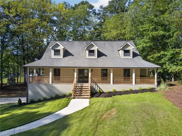 Expansive front porch with wood railings and white pillars
