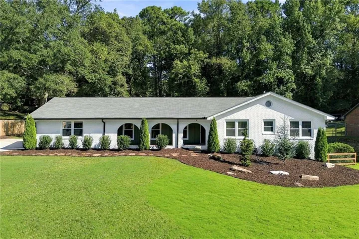 White brick exterior with a gray shingle roof