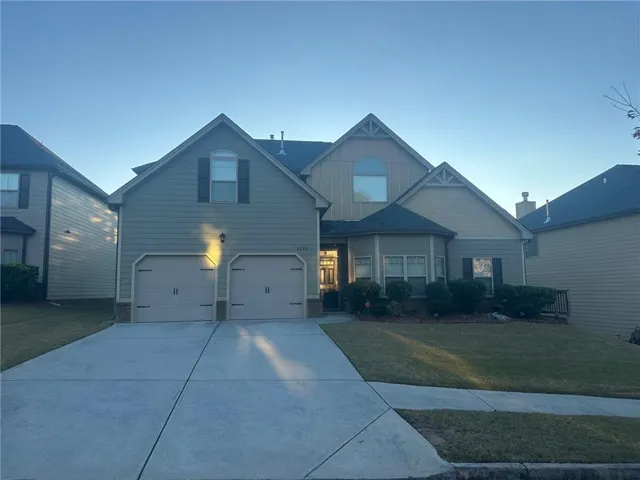 Craftsman-style home with a front yard, concrete driveway, a garage, and board and batten siding