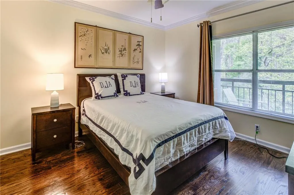 Bedroom with crown molding, dark wood-style flooring, and a ceiling fan
